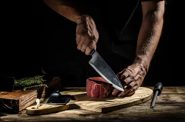 Foto op Plexiglas Steakhouse Chef slager bereidt biefstuk