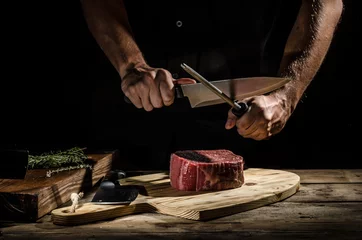 Papier Peint photo Lavable Steakhouse Le boucher de chef prépare le bifteck de boeuf
