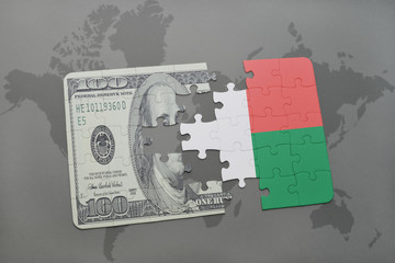 puzzle with the national flag of madagascar and dollar banknote on a world map background.