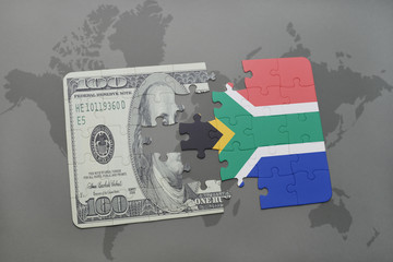 puzzle with the national flag of south africa and dollar banknote on a world map background.