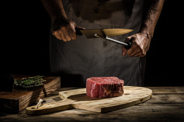 Le boucher de chef prépare le bifteck de boeuf