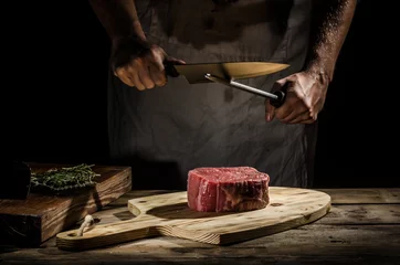 Papier Peint photo Lavable Steakhouse Le boucher de chef prépare le bifteck de boeuf