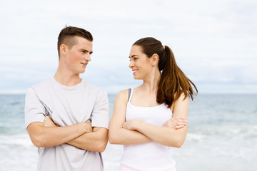 Fototapeta premium Young couple looking at each other on beach