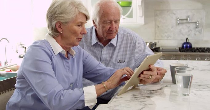 Senior Couple Use Digital Tablet For Purchase 