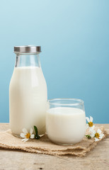 A bottle of rustic milk and glass of milk on a wooden table on a