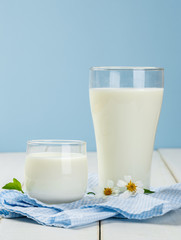 A glass of milk with Napery  on a white wooden table on a blue b