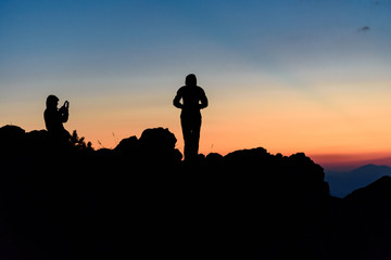 Silhouette of a couple taking self portraits, enjoying the sunset at Vitosha Mountain, Bulgaria