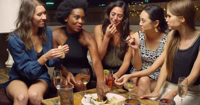 Female Friends Enjoying Night Out At Rooftop Bar 