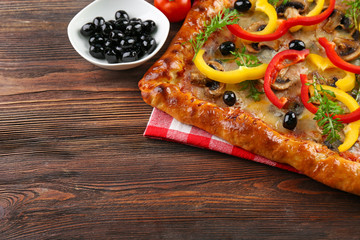 Freshly homemade pizza on wooden background