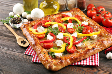 Freshly homemade pizza on wooden table closeup