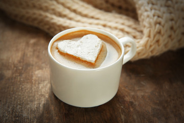 Cup of coffee with marshmallow on wooden table