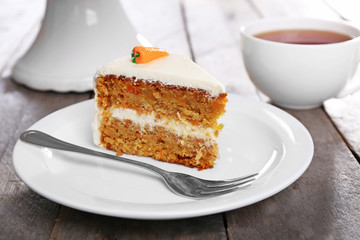 Delicious carrot cake with tea on wooden table