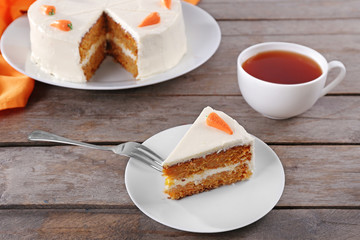 Delicious carrot cake with tea on wooden table