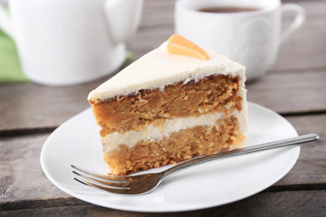 Delicious carrot cake with fork on wooden table