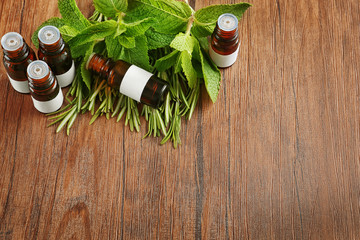 Fototapeta na wymiar Dropper bottles and herbs on wooden background