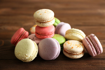 Heap of tasty macaroons on wooden background