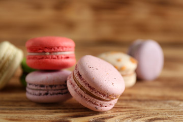 Heap of tasty macaroons on wooden background