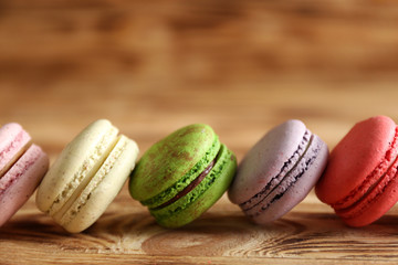 Colorful tasty macaroons on wooden background