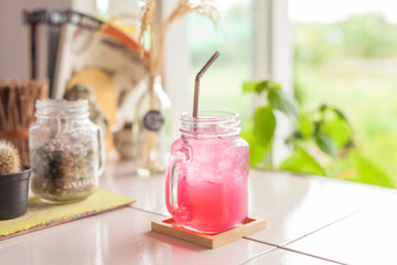 Raspberry lemonade with ice in mason jar
