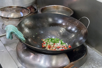 
Chef in restaurant kitchen at stove with pan
