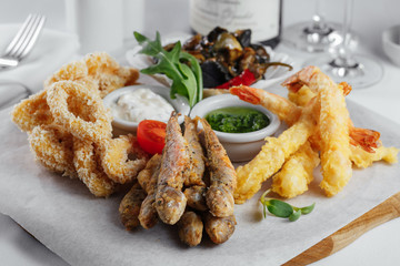 squid rings, fried fish, mussels, shrimp with tomato closeup