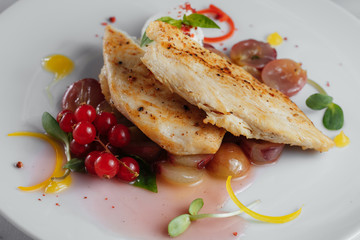 Chicken fillet with grapes and red currant closeup