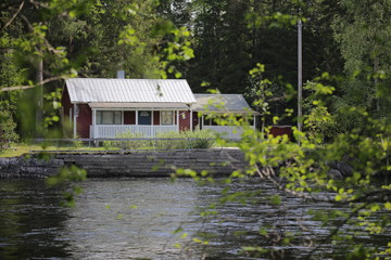 Fototapeta na wymiar Small Swedish house seen over a river