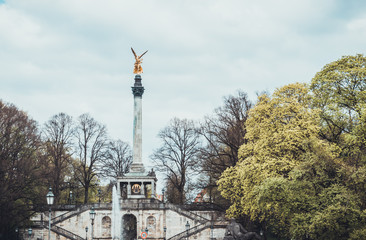 Obraz premium Golden statue atop pillar in park