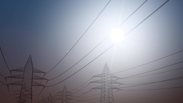 Electricity transmission. Power line against sunny sky, dolly shot. 4K seamless looping clip