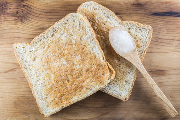 Brown whole wheat toast with sweet white jam on spoon