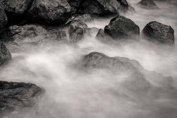motion blur water surrounding rocks, black and white