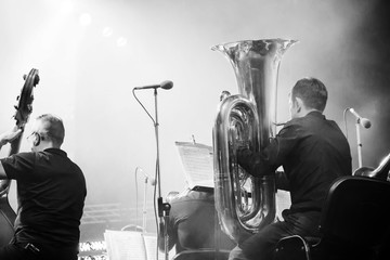 Symphony orchestra on the stage, tuba and double bass players, behind the scenes shoot in black and...