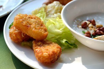 chicken nuggets and vegetable salad on a white plate..