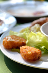 chicken nuggets and vegetable salad on a white plate..