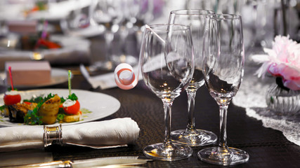 Cutlery Banquet table covered in natural crocodile skin, glasses and plates, forks and knives, napkins and buttons for a luxurious celebration in anticipation of guests. Luxury festive table. 