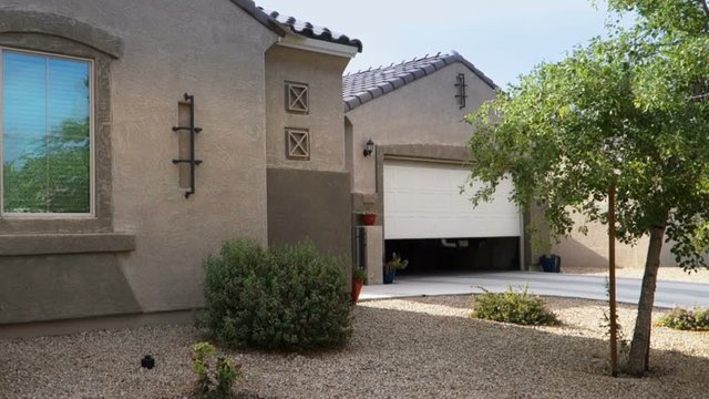 A garage door opens automatically on a home in a typical Phoenix neighborhood.	