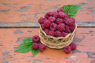 Ripe raspberries in a wicker basket. Fruit