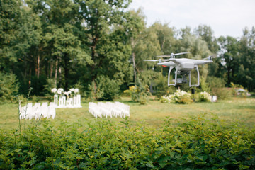 Videography wedding ceremony from the air a small spy quad copter scout drone flying through the trees in  forest.