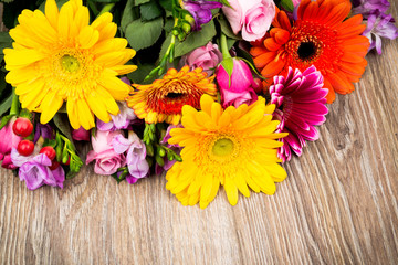 Mixed beautiful flowers on wooden background