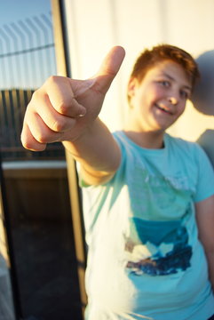 Teen boy showing thumb up representing well sign