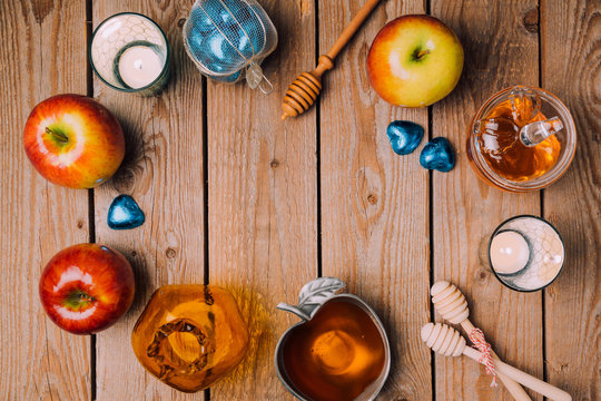 Rosh Hashana holiday background with honey, apples and candles on wooden table. View from above. Flat lay