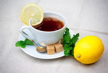 Tea with mint, brown sugar and lemon on  table