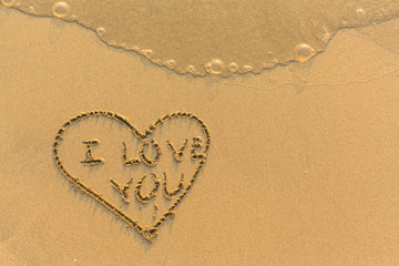 Heart and I Love You - hand-drawn in gentle sea beach sand.