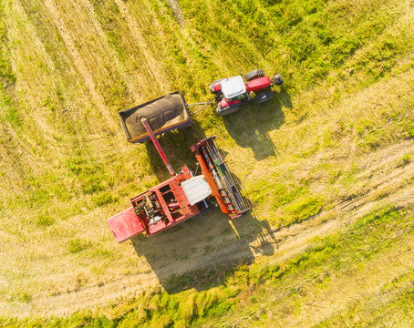 Aerial view of combine harvester and tractor. Harvest of rapeseed field. Industrial background on agricultural theme. Biofuel from Czech countryside. Agriculture and environment in European Union.