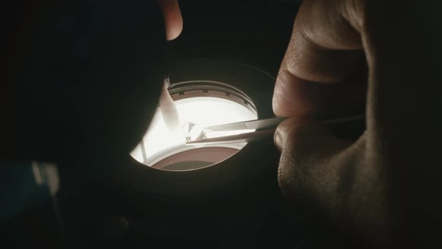  A gemologist inspecting a large diamond under a microscope