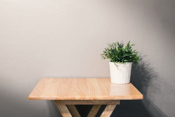 empty wooden table with pot plant on grey background