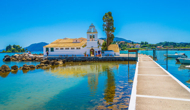 Vlacherna Monastery of Panay region on Corfu Island, Greece surrounded by turquoise sea, summer sky, and scenic pier