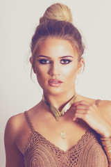 Beautiful young blonde woman with makeup and golden necklace