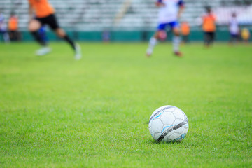 Soccer ball on the field and blur of player in stadium