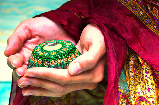 Woman's hands holding green oriental casket
